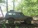 1987 Suzuki Samurai - Jeep Cherokee XJ navigates a wooded trail, tires covered in mud.