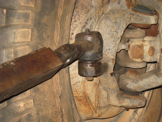 Close-up of rusty tie rod end and tire tread