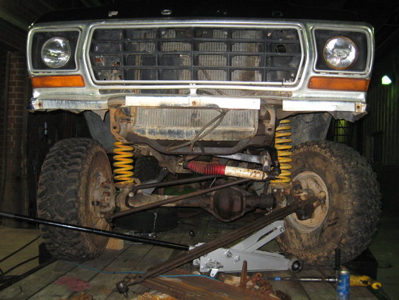 Front of a 1979 Ford truck with grille and headlights visible, showing suspension and front axle