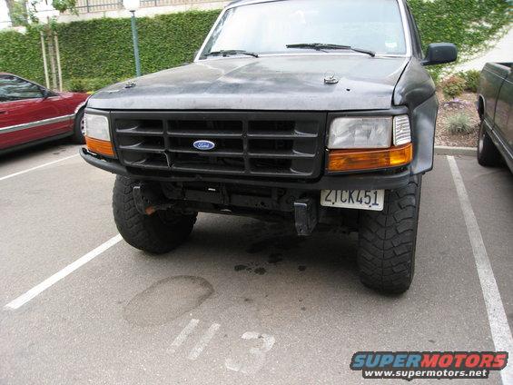 Front view of a dark gray Ford Bronco with a black grille and aftermarket bumper. License plate ZJCK451 is visible