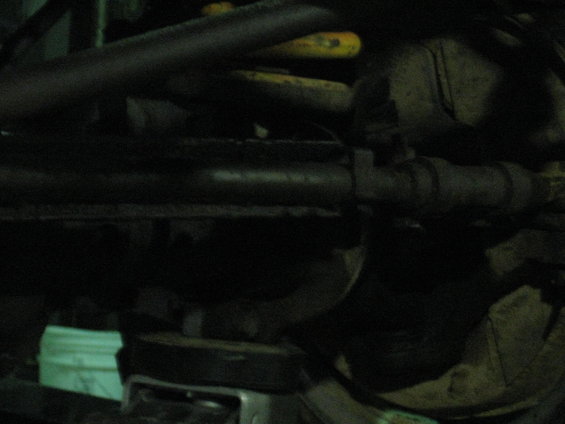 Undercarriage of a vehicle with dark pipes and yellow springs visible
