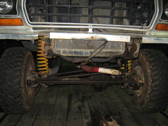 1978 Ford Bronco front suspension with yellow springs, red and white shock absorber, and grille