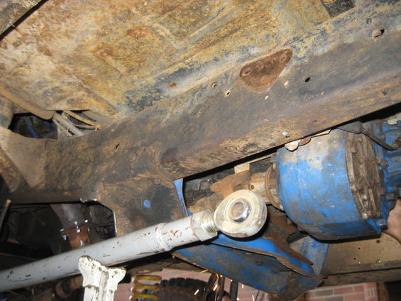 Undercarriage of a vehicle with heavy rust on the frame and a blue-painted differential