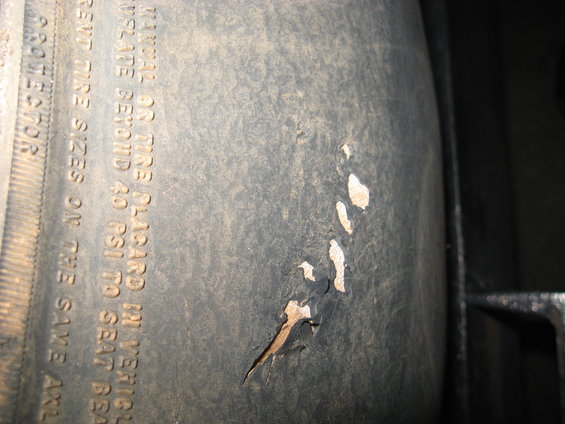 Tire sidewall with text and damage
