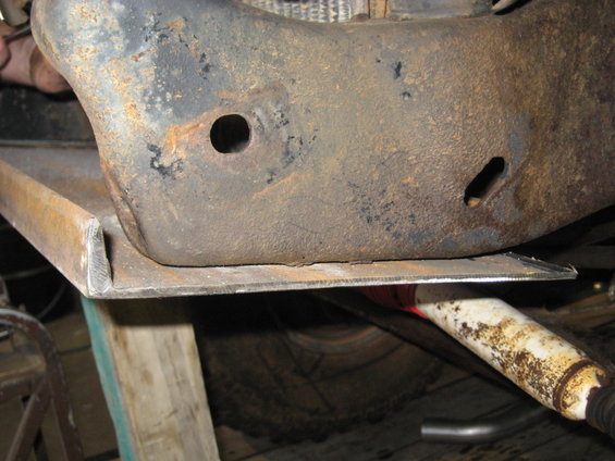 Close-up of rusted vehicle frame and shock absorber
