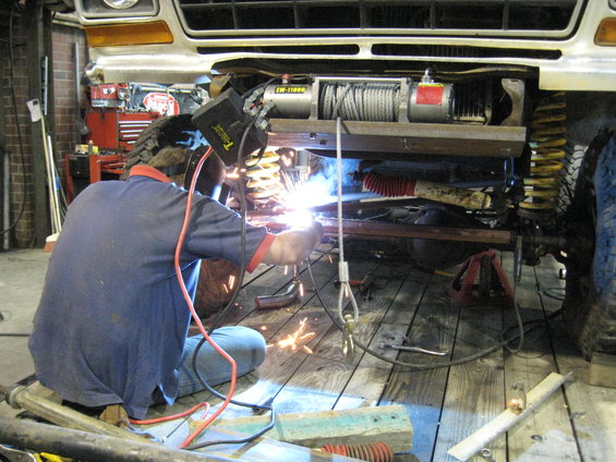1978 Ford Bronco front end being welded underneath, showing winch and suspension