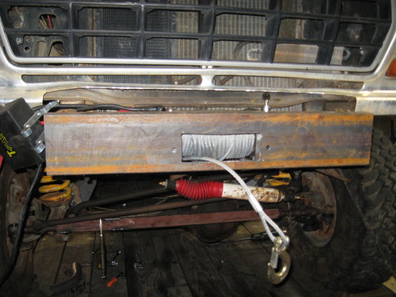 Custom winch bumper with winch and tow hook on a vehicle front