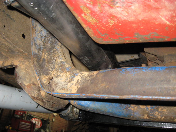 Undercarriage view showing rusty frame components and exhaust pipe