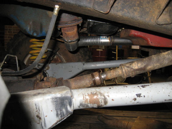 Undercarriage view of a vehicle with yellow springs and exhaust components