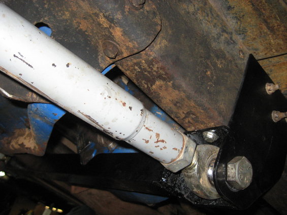 Underbody suspension component with white shock absorber and black bracket