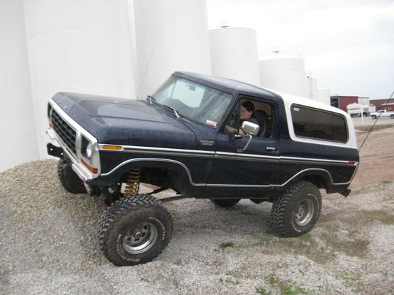 Dark blue 1978 Ford Bronco with a white top on a gravel incline