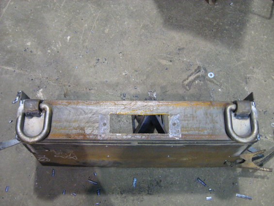 Fabricated metal part with two D-rings and a central rectangular cutout