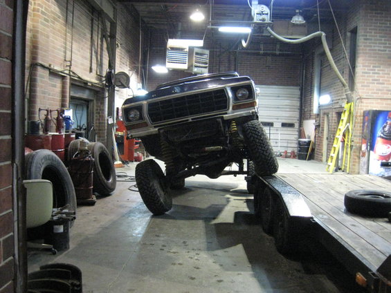 Ford Bronco on a trailer in a garage, front end angled up