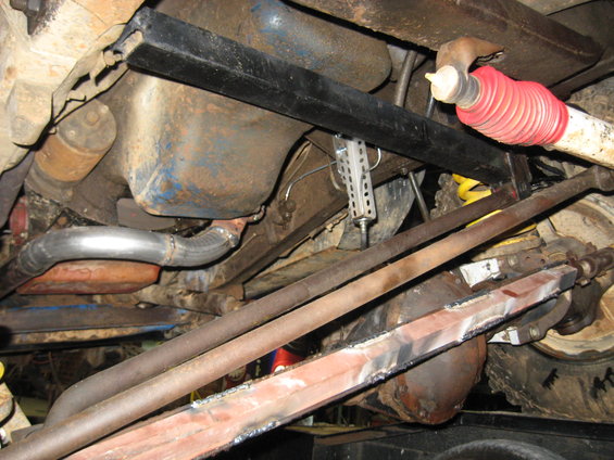 Undercarriage view showing suspension components, exhaust pipe, and differential