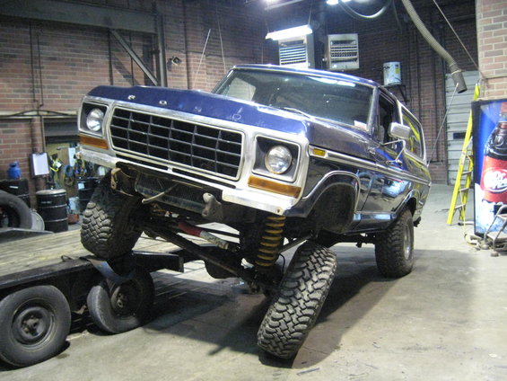 Blue 1978 Ford Bronco with lifted suspension on a trailer