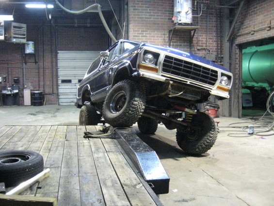 Dark blue 1978 Ford Bronco on a lift inside a garage