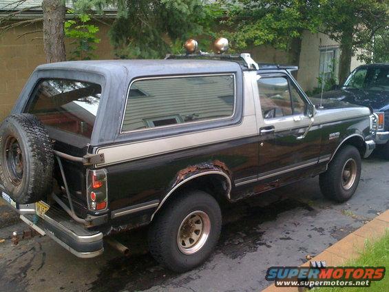 1988 Ford Bronco parked outside, showing rust on rear fender