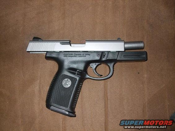 Silver slide pistol with black grip, side view