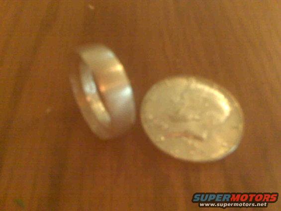 Coin and ring on wooden surface