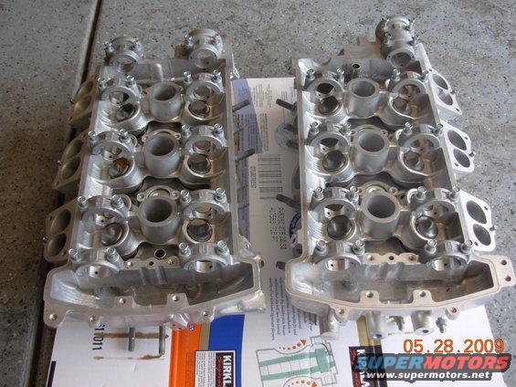 Pair of aluminum engine cylinder heads on a box with a date stamp