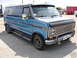 1978 Ford E150 - This blue van has a distinctive grille and chrome accents, suggesting an earlier model year than claimed.