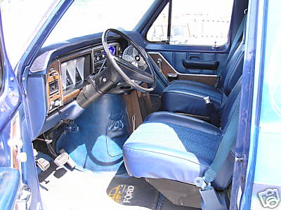 Blue interior of a 1978 Ford E150 van, showing dashboard and seats