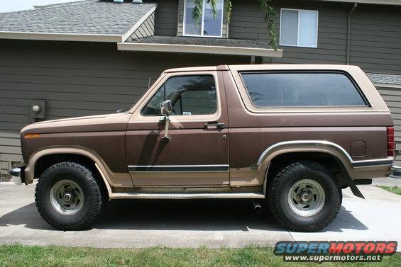 1984 Ford Bronco parked in front of a house, side view