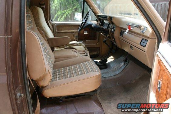 Interior view of a brown truck showing front seats, dashboard, and floor