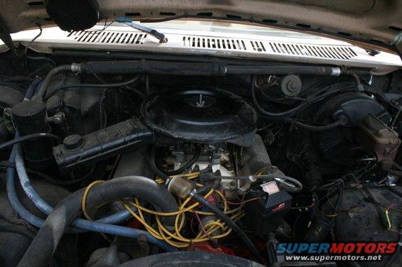 Engine bay with carburetor and yellow spark plug wires