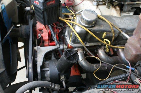 Close-up of a vehicle's engine bay, showing belts, hoses, and engine components