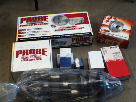 Boxes of Probe Industries forged pistons and connecting rods, plus a crankshaft damper and a crankshaft