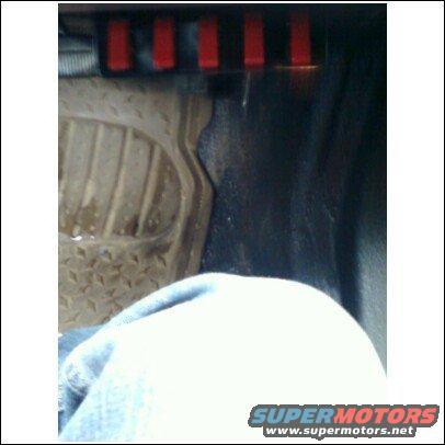 Close-up of a vehicle's floor mat and red switches above it