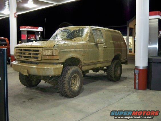 Mud-covered 1996 Ford Bronco 3/4 front view at gas station