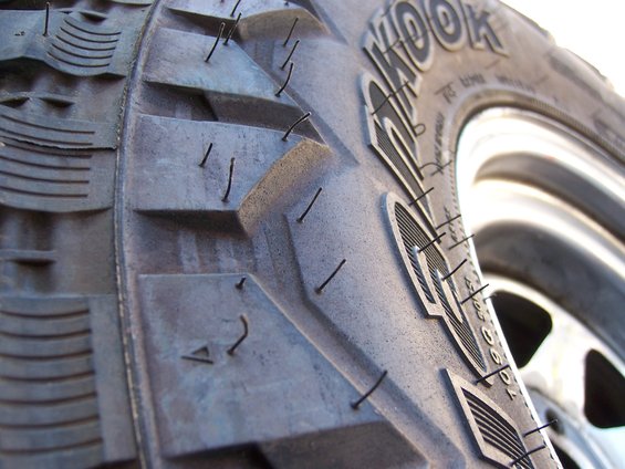 Close-up of a tire tread with embedded wires and visible 'KOOK' branding