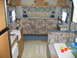 1996 Dodge 2500 - The interior of a recreational vehicle features a sofa, dinette, and a small kitchen area.