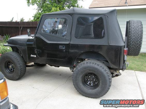 Black Jeep CJ7 with soft top and spare tire