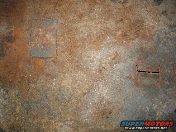 Rusted floor panel with square patch and cutout