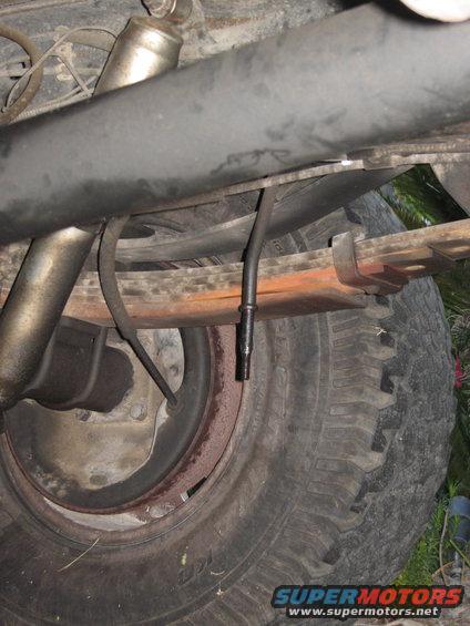 Rear suspension with leaf springs and a tire