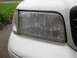 2000 Ford Crown Victoria - Close-up of the front headlight and grille of a white 2000 Ford Crown Victoria.