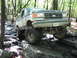 1991 Ford Bronco - This Ford Bronco is navigating a rocky trail in a wooded area.