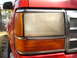 1992 Ford Explorer - Close-up of the front passenger side headlight and turn signal assembly on a red 1992 Ford Explorer.