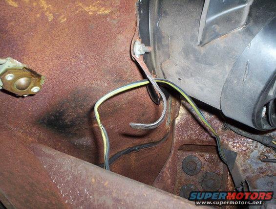 rusted metal panel with yellow and black wires connected to a fan housing