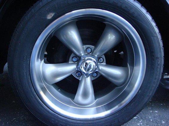 Close-up of a silver five-spoke aftermarket wheel with a chrome center cap and BFGoodrich tire