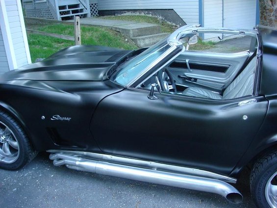 Side view of a black Stingray convertible with side pipes