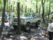 1991 Ford Bronco - A Ford Bronco tackles a challenging off-road course in a wooded area.