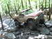 1991 Ford Bronco - This heavily modified pickup truck is navigating a rocky trail in a wooded area.