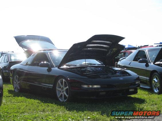 Black 1994 Ford Probe with hoods open, parked on grass next to another car