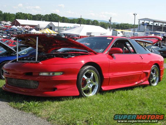 1994 Ford Probe with hood open, parked on grass at an outdoor event