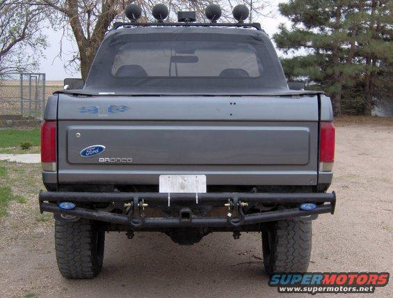 Rear view of a gray 1987 Ford Bronco with a soft top and aftermarket bumper