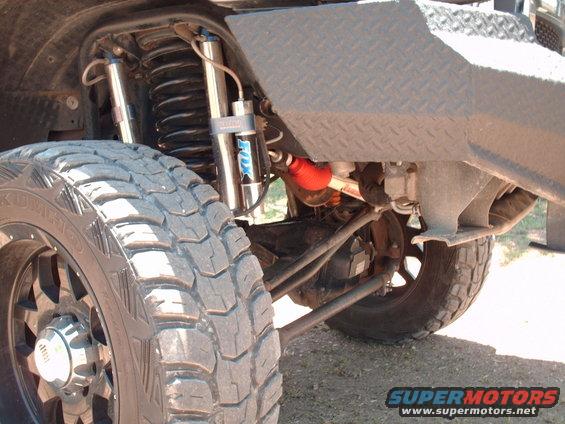 Close-up of a large off-road tire and front suspension with Fox shocks